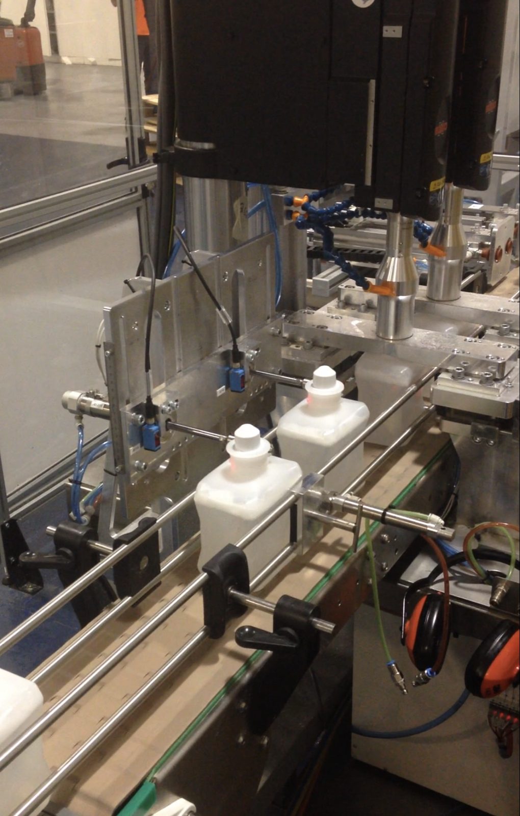 Ultrasonic welding heads over bottles on a filling line